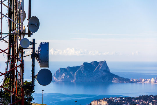 Telecommunication antennas in the Cumbre del Sol mountain, also known as "Puig Llorenca" in Benitatxell, Spain. Ifach Rock and Calpe city is in the background.