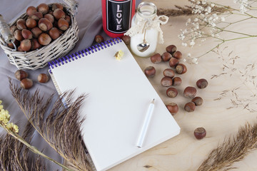 Concept of mood. waiting for spring. nuts, milk, notebook and herbarium.
