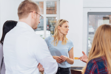 Woman standing listening in a business meeting