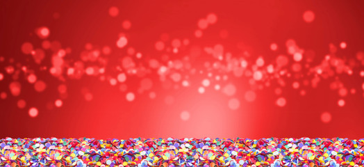 Colorful confetti in front of red background with bokeh for carnival