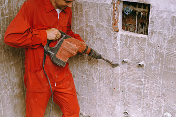Fototapeta premium Handyman using drill machine to remove tiles