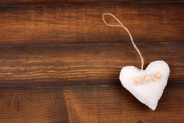 top view soft toy in a shape of heart on a wooden background copy space