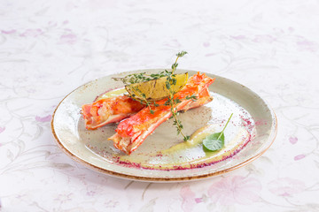 cooked crab meat on a plate, with a slice of lemon and thyme sprigs, top view