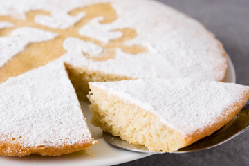 Fototapeta na wymiar Tarta de Santiago. Traditional almond cake slice from Santiago in Spain on gray background. Close up