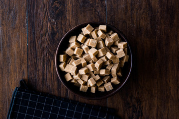 Raw Organic Brown Sugar Cubes in Wooden Bowl Ready to Eat.