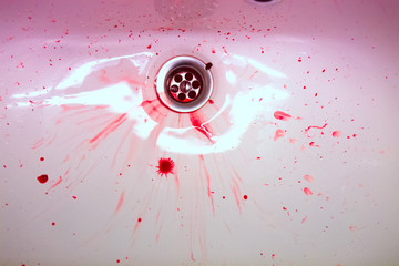 White ceramic sink with red blood stains. The concept of bloody 