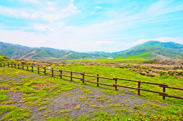 Fototapeta na wymiar Beautiful landscape view of Kusasenri Ga Hama Grassland is green grass field for grazing with Mountain Eboshi-dake ,where is famous scenic spot in Aso Kuju National Park ,Kumamoto ,Kyushu ,Japan