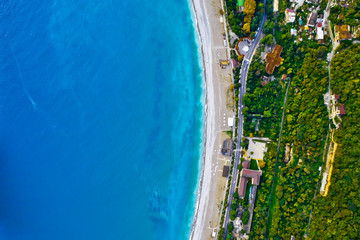 Aerial view from top to bottom of the turquoise sea with green trees