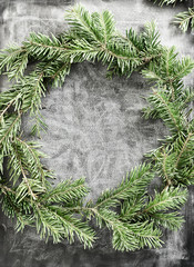 Top view flat lay green Christmas wreath on chalkboard covered with white chalk. Traditional New year decoration concept. Space for lettering