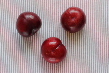 three natural fresh plums on table