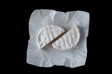 Camembert on a black background. Top view.