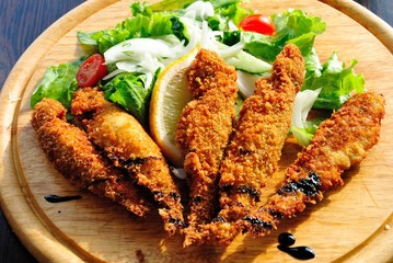 Red mullets (Mullus barbatus) fried in bread crumbs and served with green salad and lemon