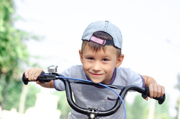 Obraz premium Smiling boy riding bicycle
