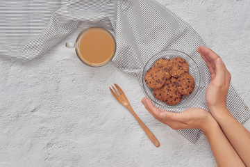 Plate of cookies in male hands on dark old wooden background top view