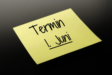 Termin 1. Juni - gelber Notizzettel dunkler Hintergrund