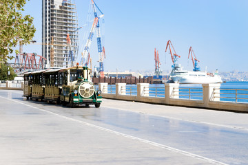 Obraz na płótnie Canvas Park area. Beach side. fun train for child. Cargo ship in the Caspian Sea Baku, Azerbaijan