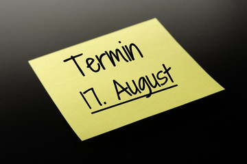 Termin 17. August - gelber Notizzettel dunkler Hintergrund