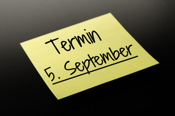 Termin 5. September - gelber Notizzettel dunkler Hintergrund