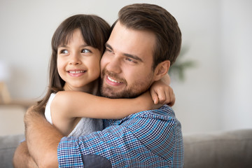 Fototapeta premium Hopeful single dad embracing cute kid daughter looking into bright future vision thinking of new goals, little child girl hugging loving father dreaming planning family good expectations concept