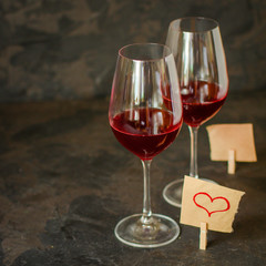 red wine, transparent glass (beverage and a note with a heart). top