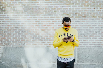 Portrait of handsome afro man using his mobile.