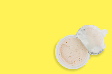 Single plastic jar of pate on yellow background with copy space for your text