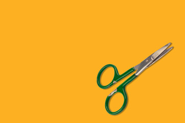 Old worn metal scissors on orange background with copy space for your text