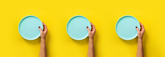 Pattern of female hands holding empty blue plate on yellow background with copy space. Healthy...