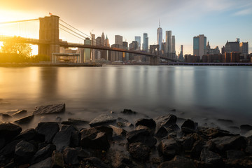 Evening by the East River in New York City. View of Brooklyn Bridge and Lower Manhattan during...