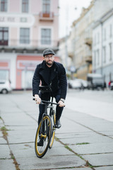 Lifestyle, transport and people concept. Young bearded man with riding bicycle on city street