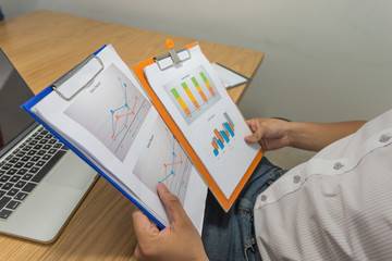 Young businessman reading sales reports in the office