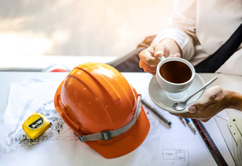Young Architect man doing hand holding coffee mug while taking relax a break from work. Project...
