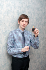 The young Russian guy holds a bottle of men's perfumery water in hand.