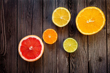 Bright citrus fruits on a wooden dark background