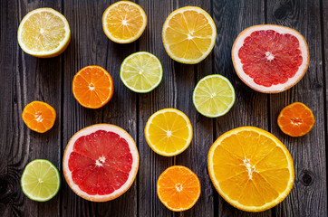 Fototapeta na wymiar Bright citrus fruits on a wooden dark background