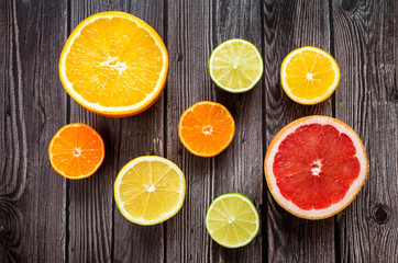 Fototapeta na wymiar Bright citrus fruits on a wooden dark background