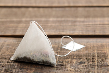 tea bag pyramid closeup on a brown wooden table. space for text