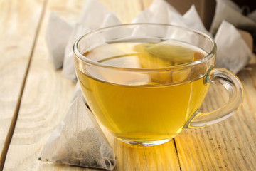 cup with tea and tea bag pyramid. close-up. on a wooden table. to make tea