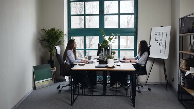 Two caucasian women working in the architect office.
