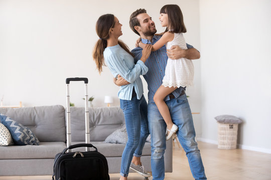 Welcome Back Dad Concept, Happy Father Businessman Embracing Kid Child Daughter And Young Wife Returning From Business Trip, Loving Daddy Arriving Coming Home Excited By Family Reunion Concept