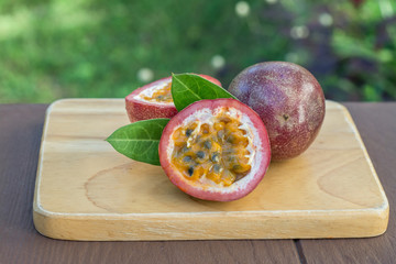 a passion fruit on the wooden table on the background of tropical garden