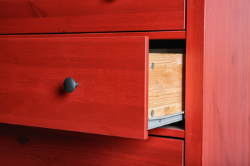 Red chest of drawers, closeup. Stylish furniture for wardrobe room