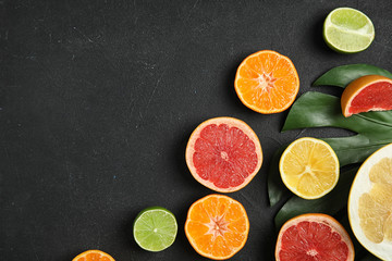 Different citrus fruits on black background, flat lay. Space for text