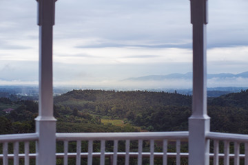 Fototapeta premium Wooden balcony overlooking the white mist mountain