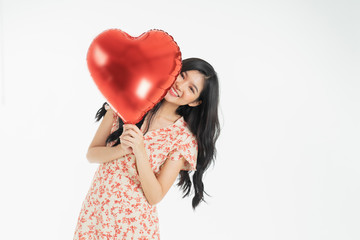 Asian young woman in red dress  red ballon heart. Young woman holding it with  being excited and surprised  holiday present isolated white  background.concept love surprise valentine day.