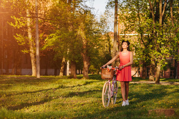 Obraz premium Latin woman in pink dress with flowers and pink bicycle.