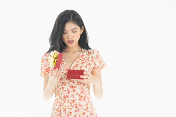   asian curious woman in red dress rejoicing her birthday or new year gift box. Young woman holding gift  box with red bow being excited and surprised  holiday present isolated white  background