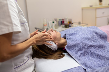 Obraz na płótnie Canvas Young woman getting a facial massage
