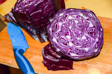 cooking red fresh raw cabbage ornament on  wooden board blue knife 