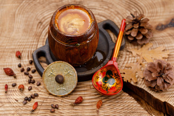 Barrel with honey and painted wooden Russian spoon.